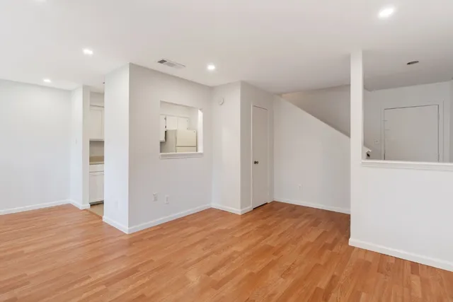 a view of empty room with wooden floor