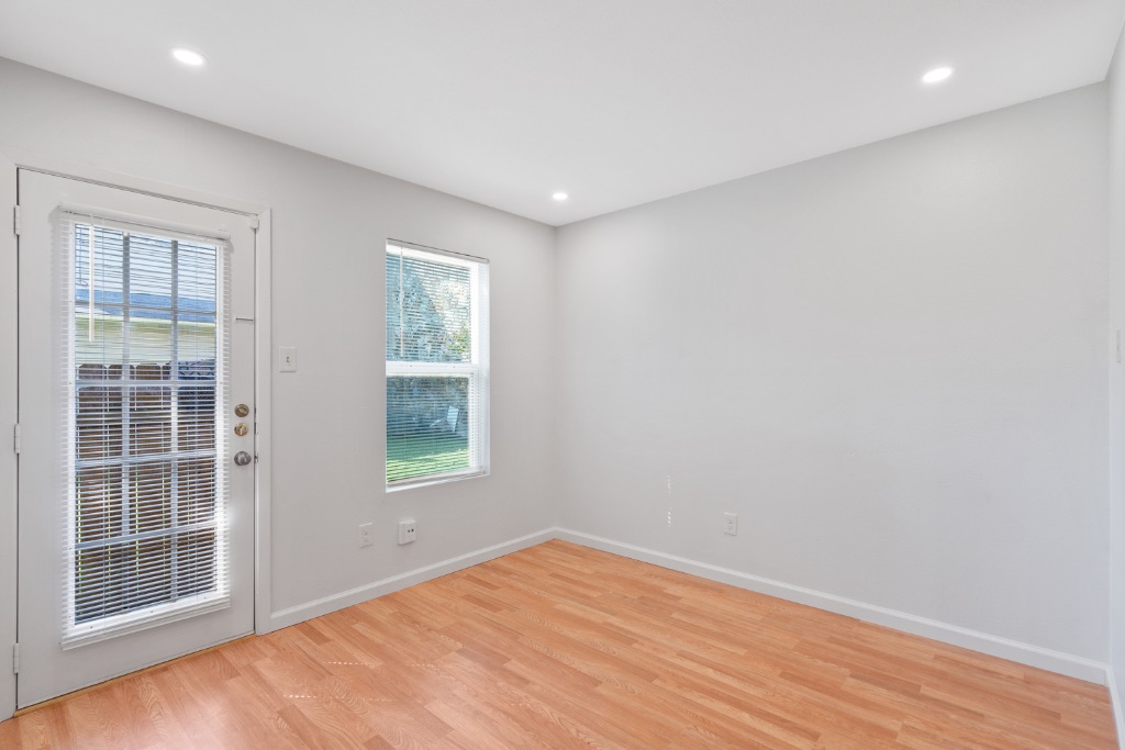 8703 Schick Road, Unit A Austin, TX 78729 - Photo 7 of 21 an empty room with wooden floor and windows