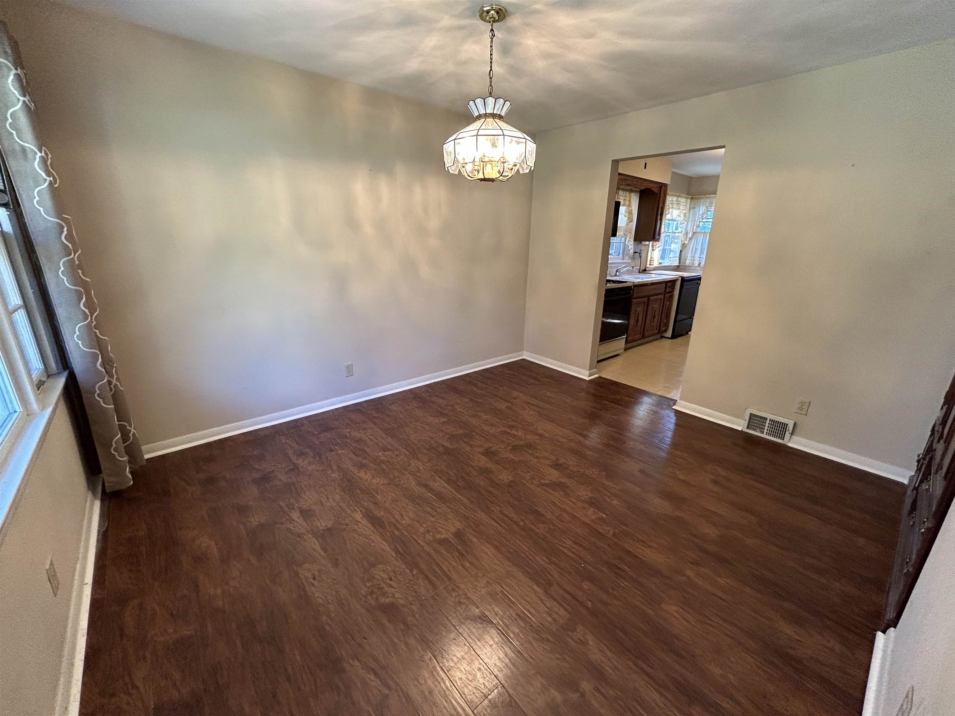 4003 Pinecrest Road Rockford, IL 61107 - Photo 5 of 16 an empty room with wooden floor chandelier and windows