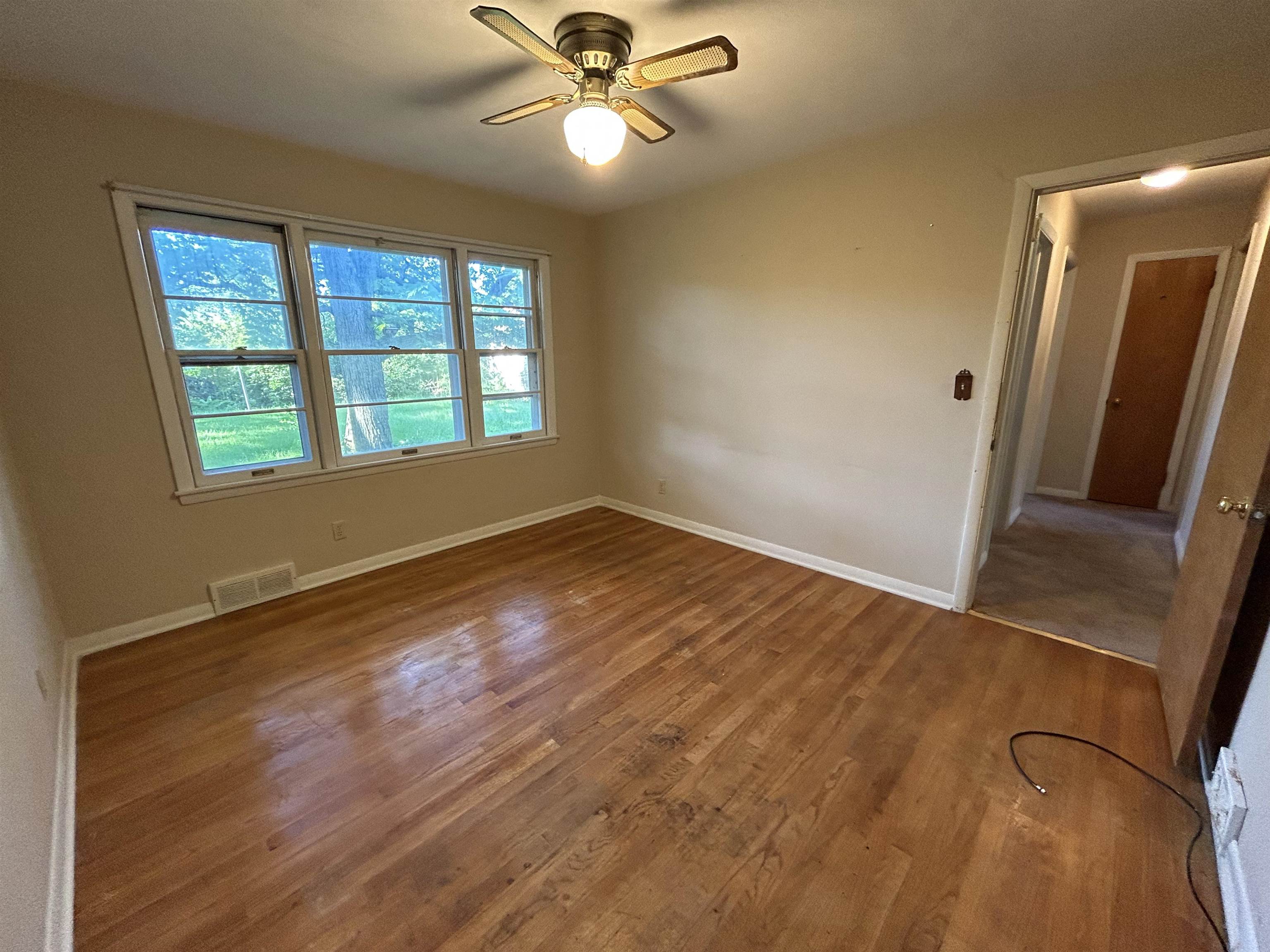 4003 Pinecrest Road Rockford, IL 61107 - Photo 8 of 16 a view of an empty room with wooden floor and a window