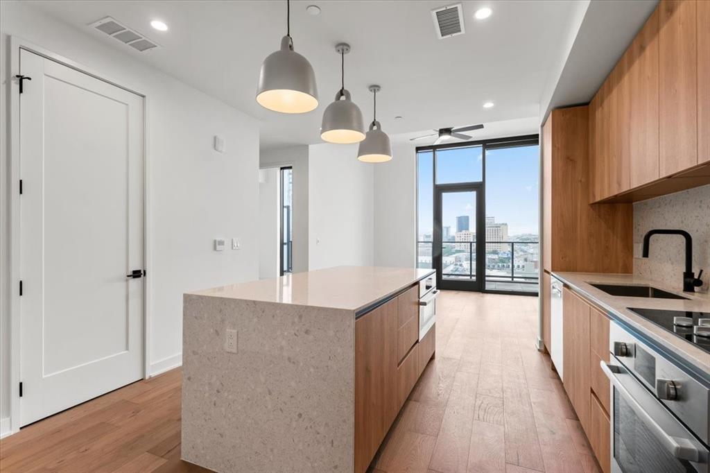a large kitchen with stainless steel appliances granite countertop a lot of counter space and a sink