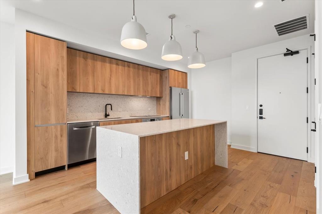 84 East Avenue, Unit 1202 Austin, TX 78701 - Photo 4 of 39 a kitchen with kitchen island a sink a center island a stove and a window