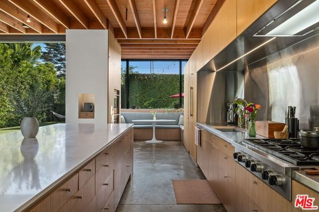 a kitchen with stainless steel appliances a stove a sink and wooden cabinets