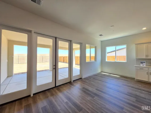 a view of an empty room with window and wooden floor