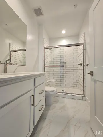 a bathroom with a sink a toilet and shower