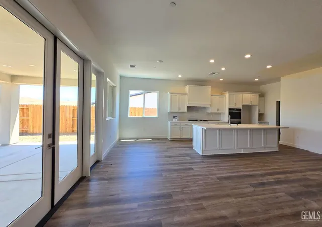 a view of kitchen with kitchen island wooden floors and a sink