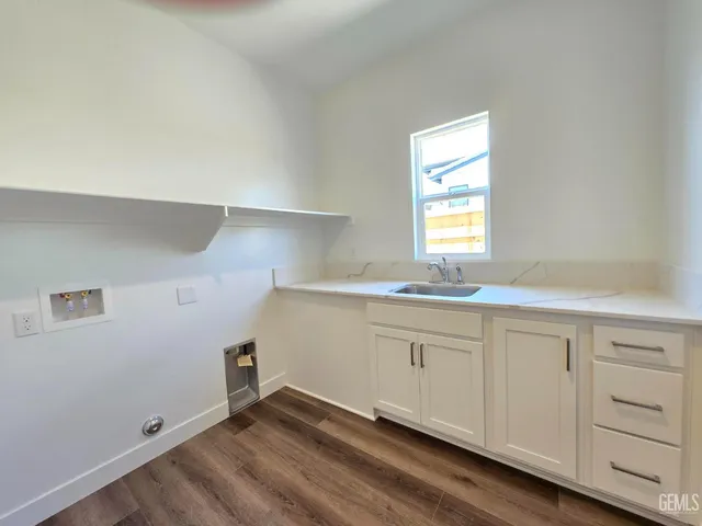 a kitchen with granite countertop white cabinets and a window