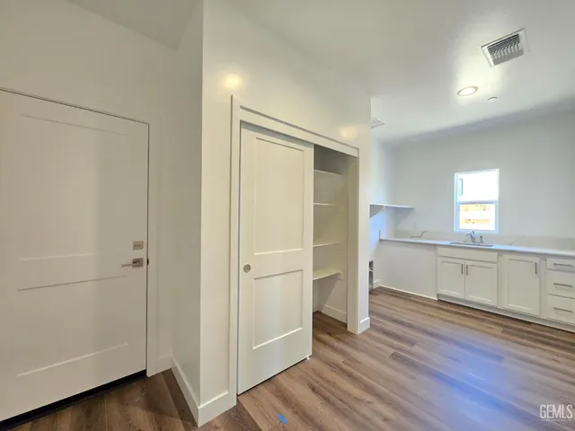a view of a kitchen with wooden floor and electronic appliances