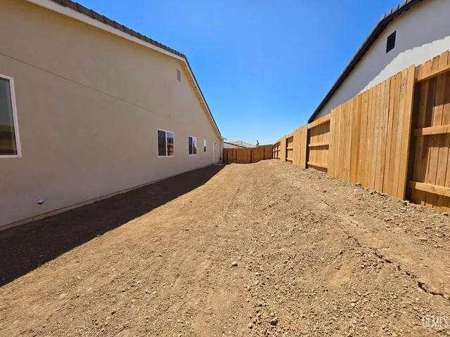 a view of an house with backyard and wooden fence