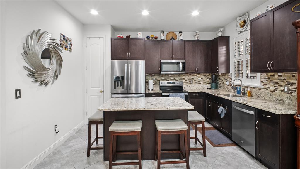 6993 Pines Circle, Unit 6993 Pompano Beach, FL 33073 - Photo 20 of 33 a kitchen with kitchen island granite countertop a sink and a refrigerator
