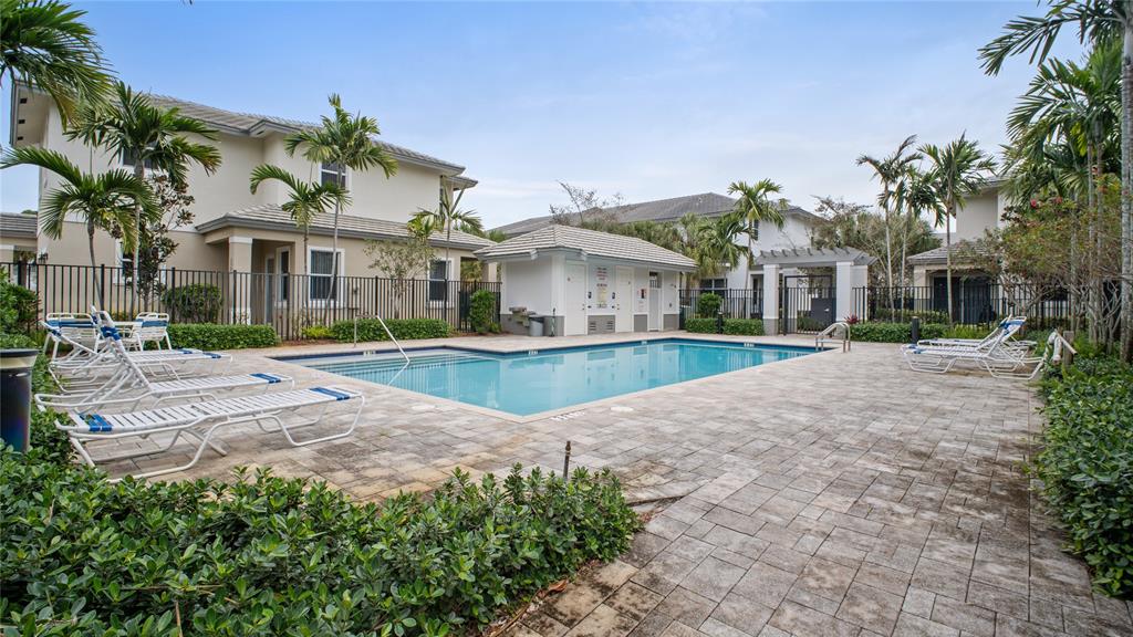 6993 Pines Circle, Unit 6993 Pompano Beach, FL 33073 - Photo 30 of 33 a view of a white house with a yard and potted plants