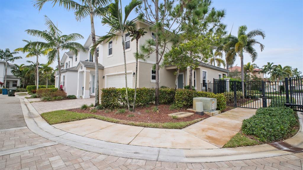6993 Pines Circle, Unit 6993 Pompano Beach, FL 33073 - Photo 31 of 33 a view of a white house with a yard plants and palm trees