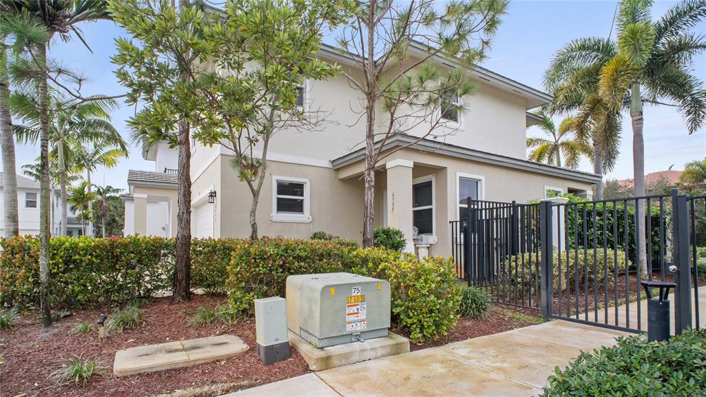 6993 Pines Circle, Unit 6993 Pompano Beach, FL 33073 - Photo 32 of 33 a front view of a house with a garden