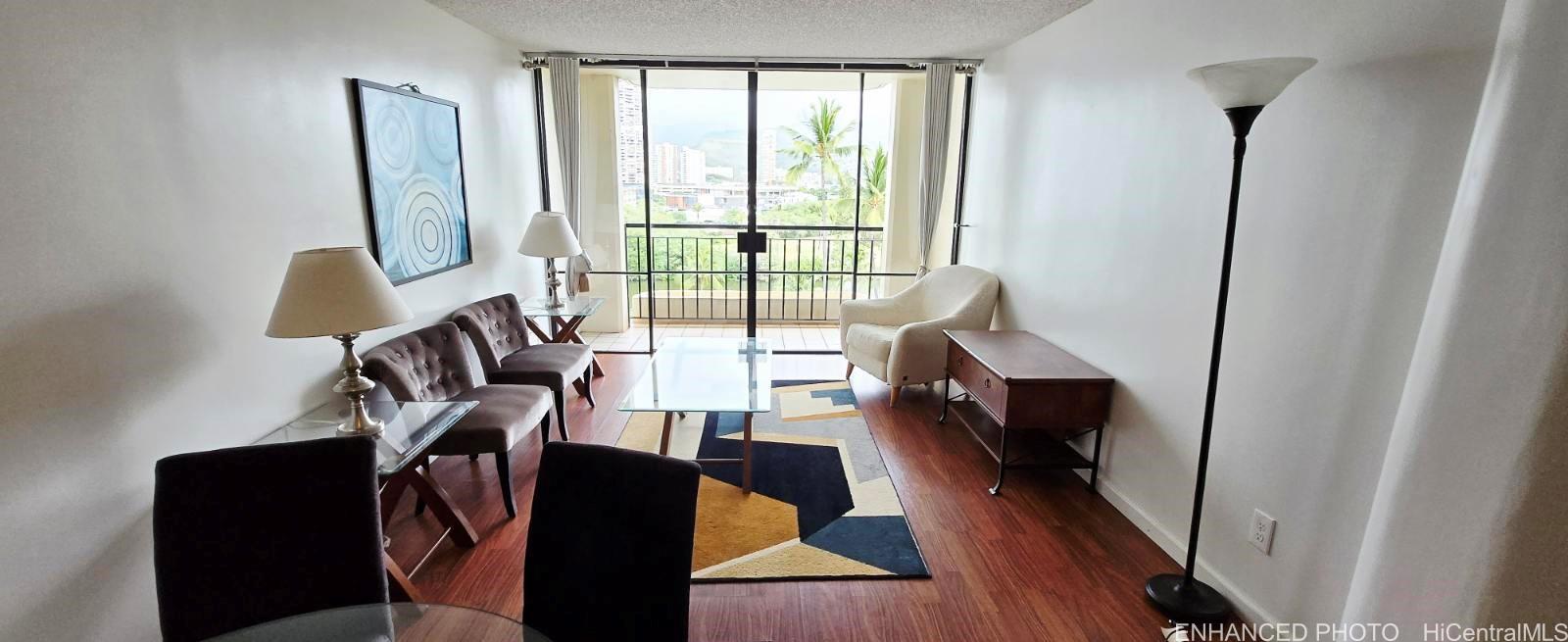 440 Seaside Avenue, Unit 702 Honolulu, HI 96815 - Photo 1 of 14 a living room with furniture and a wooden floor