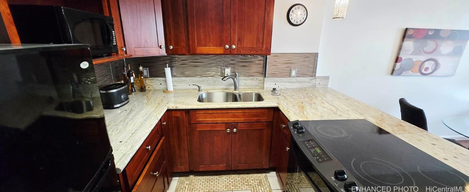 440 Seaside Avenue, Unit 702 Honolulu, HI 96815 - Photo 4 of 14 a kitchen with stainless steel appliances granite countertop a stove a sink and a microwave