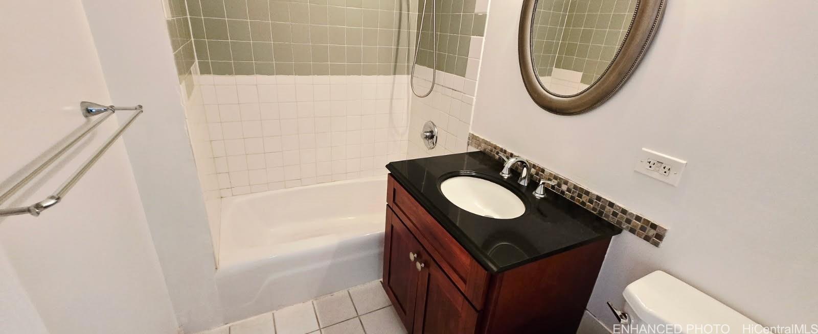 440 Seaside Avenue, Unit 702 Honolulu, HI 96815 - Photo 10 of 14 a bathroom with a sink a toilet and a mirror