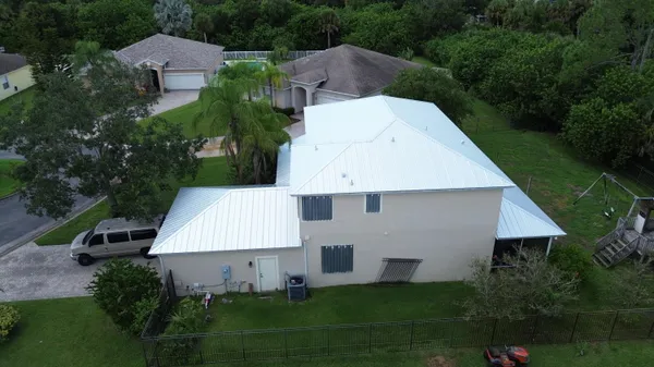 an aerial view of a house with swimming pool and patio