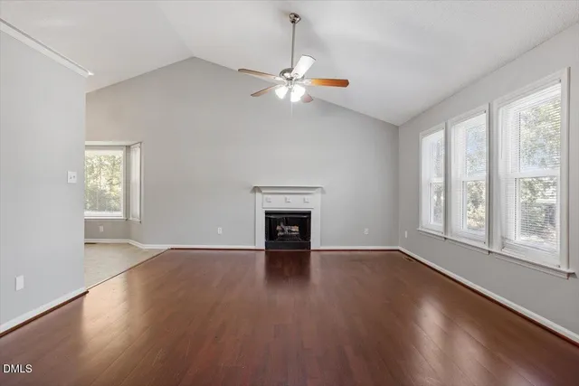 wooden floor fireplace and windows in an empty room