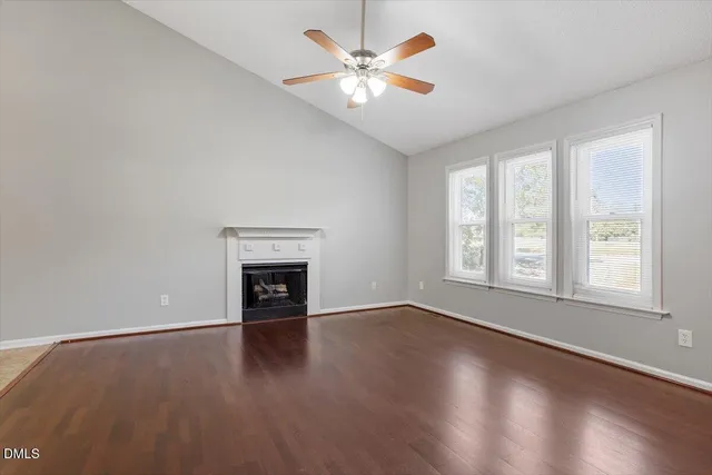 an empty room with windows and a fireplace
