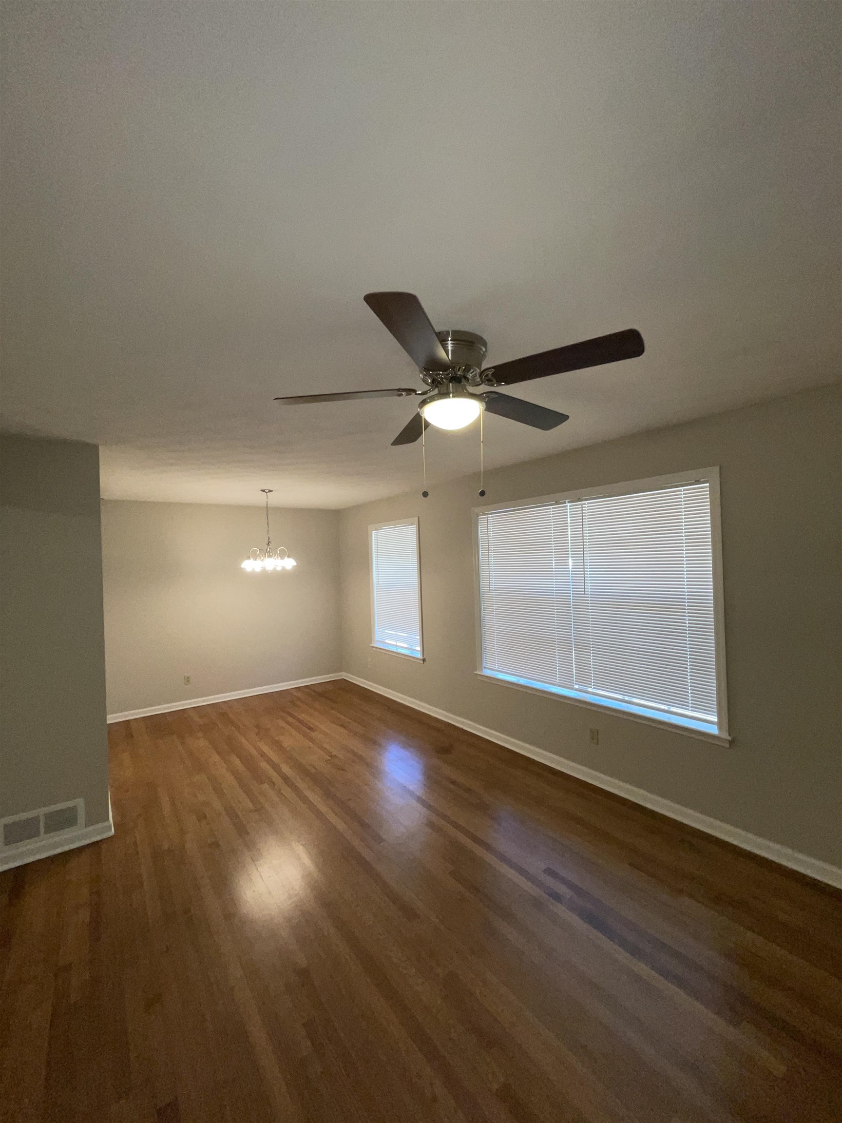 2987 Ruskin Road Bartlett, TN 38134 - Photo 3 of 12 an empty room with wooden floor fan and windows
