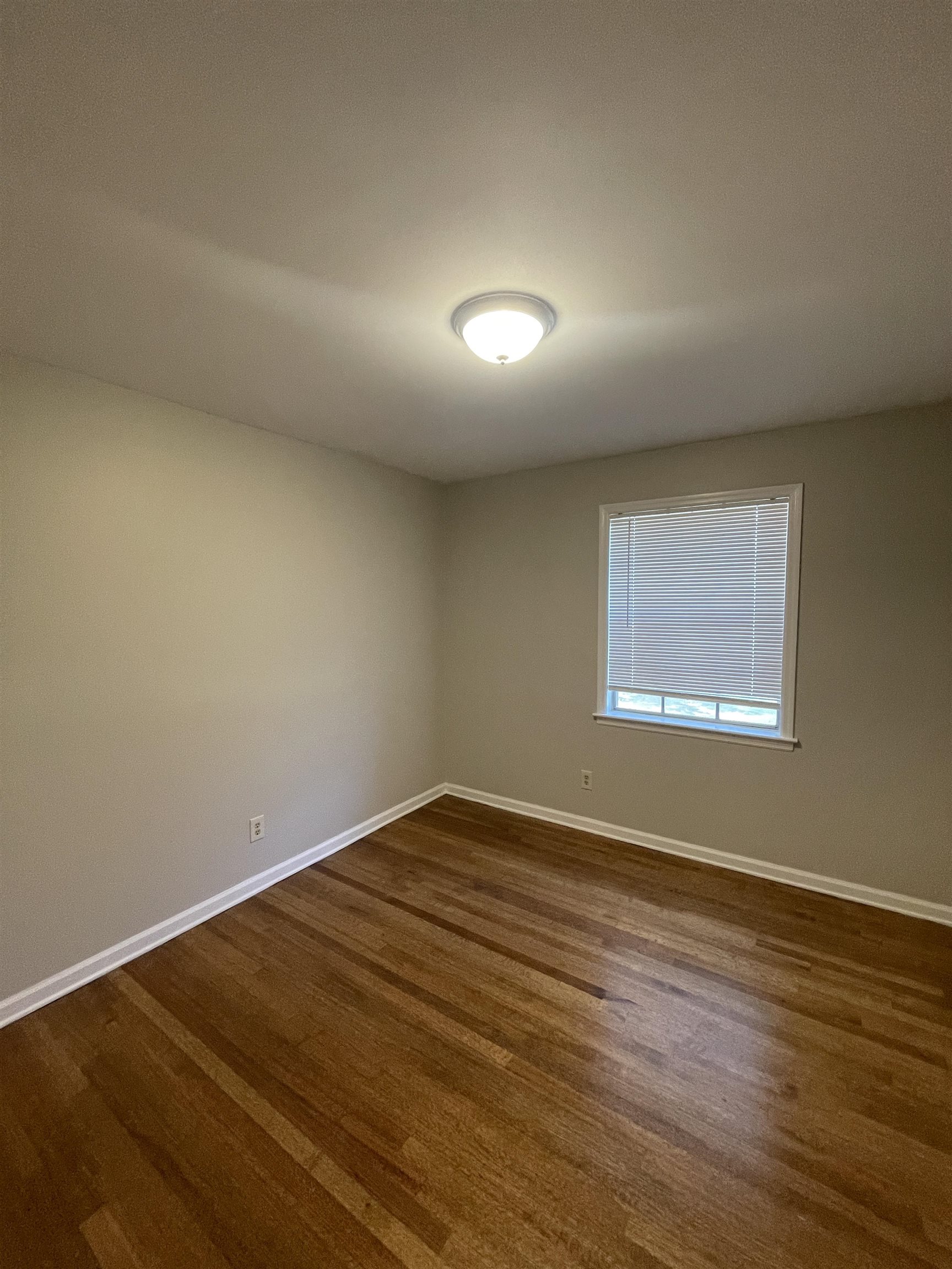 2987 Ruskin Road Bartlett, TN 38134 - Photo 8 of 12 an empty room with wooden floor and windows
