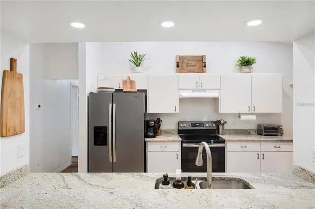 a view of a hallway with wooden floor and a bathroom