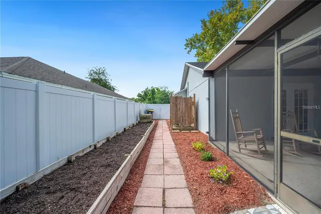 a view of a backyard with table and chairs and a large tree