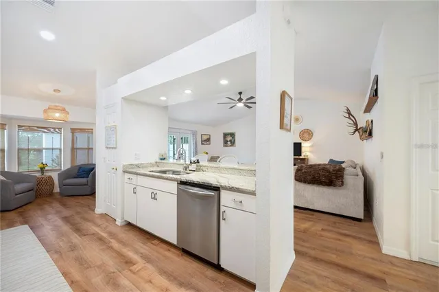 a large kitchen with stainless steel appliances granite countertop a lot of counter space and wooden floor