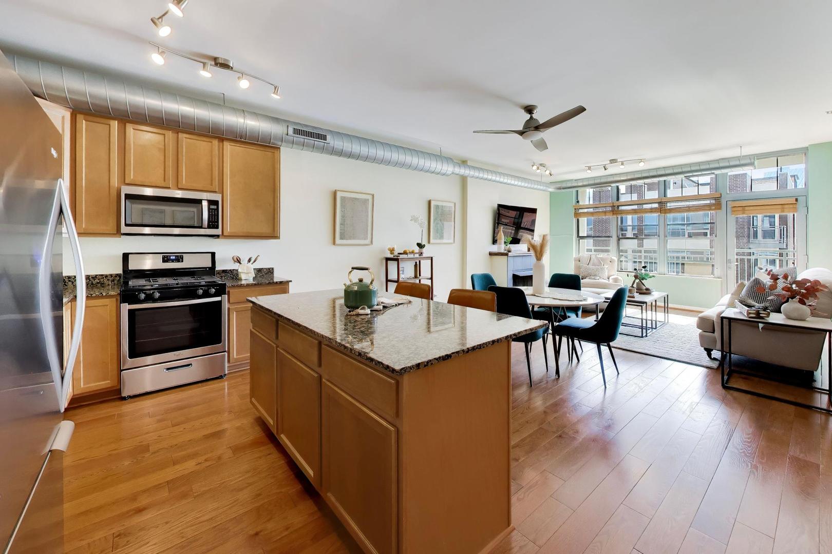 1200 West Monroe Street, Unit 502 Chicago, IL 60607 - Photo 10 of 34 a kitchen with stainless steel appliances granite countertop a stove top oven a sink dishwasher a dining table and chairs with wooden floor