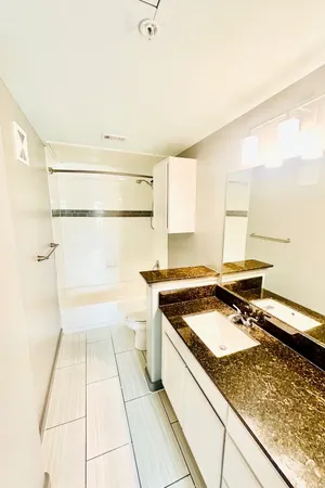 a kitchen with granite countertop a stove a sink and a microwave