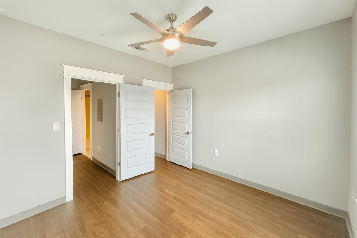 200 Maple Lane, Unit 1201 Elgin, TX 78621 - Photo 16 of 23 an empty room with wooden floor and a ceiling fan