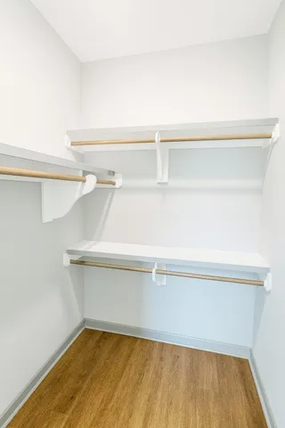 an empty room with a ceiling fan and wooden floor