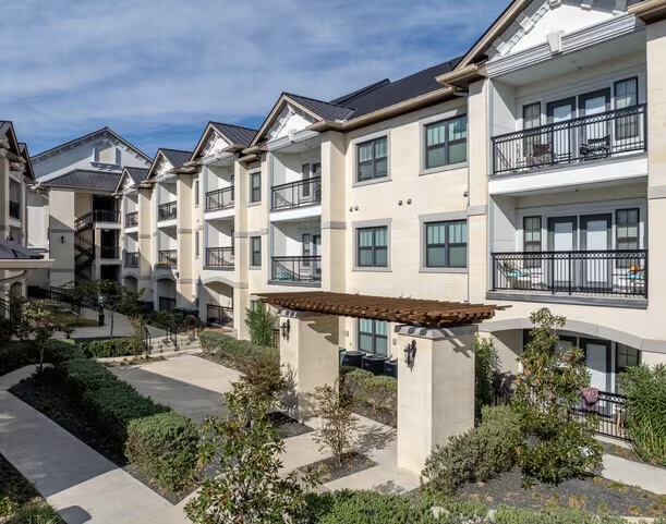 200 Maple Lane, Unit 1201 Elgin, TX 78621 - Photo 4 of 23 a view of a large building with a lot of plants and many windows