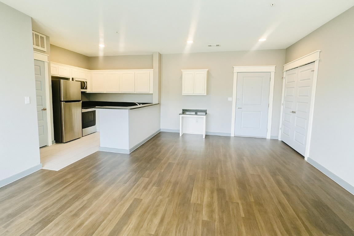 200 Maple Lane, Unit 1201 Elgin, TX 78621 - Photo 22 of 23 a kitchen with stainless steel appliances wooden floors and large window