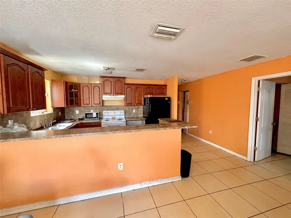 a view of kitchen with stainless steel appliances a refrigerator and a stove top oven