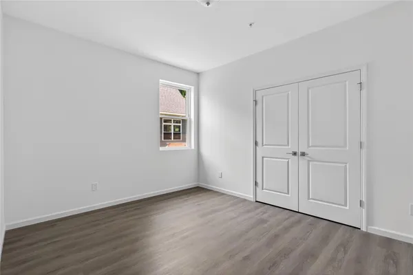 a view of an empty room with wooden floor