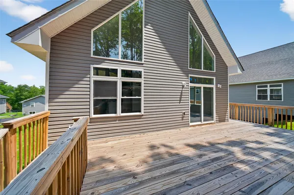 a view of a house with a large window and wooden fence