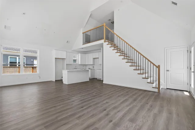 a view of a livingroom with wooden floor and stairs