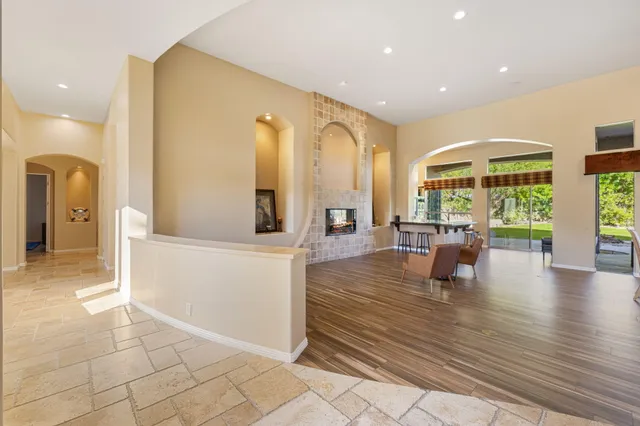 a kitchen with stainless steel appliances granite countertop a stove a refrigerator a kitchen island a table and chairs