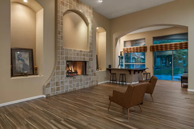 a kitchen with stainless steel appliances granite countertop a stove top oven a sink a dining table and chairs