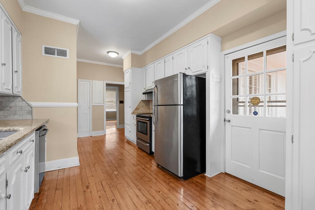 1500 Preston Drive Columbus, GA 31906 - Photo 8 of 29 a kitchen with a refrigerator a stove top oven a wooden floor and a window