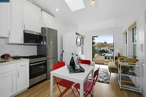 a kitchen with stainless steel appliances a stove a sink dishwasher a microwave oven with a dining table and chairs