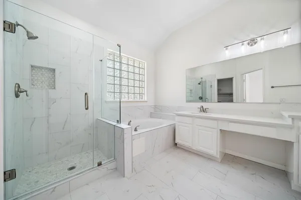 a spacious bathroom with a shower sink and mirror