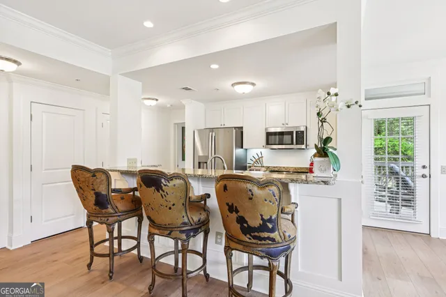 a dining room with furniture a chandelier and wooden floor