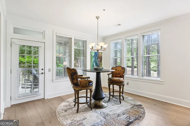 a dining room with furniture a chandelier and wooden floor