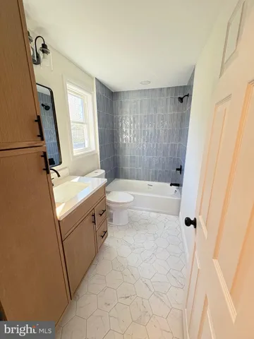 a bathroom with a sink a toilet a mirror a vanity and window