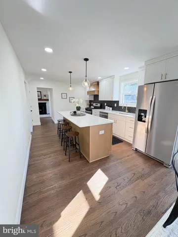 a kitchen with refrigerator cabinets and wooden floor
