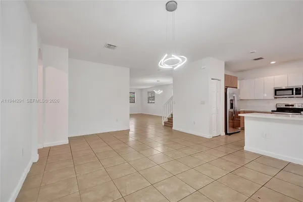 a view of kitchen with granite countertop cabinets and white appliances