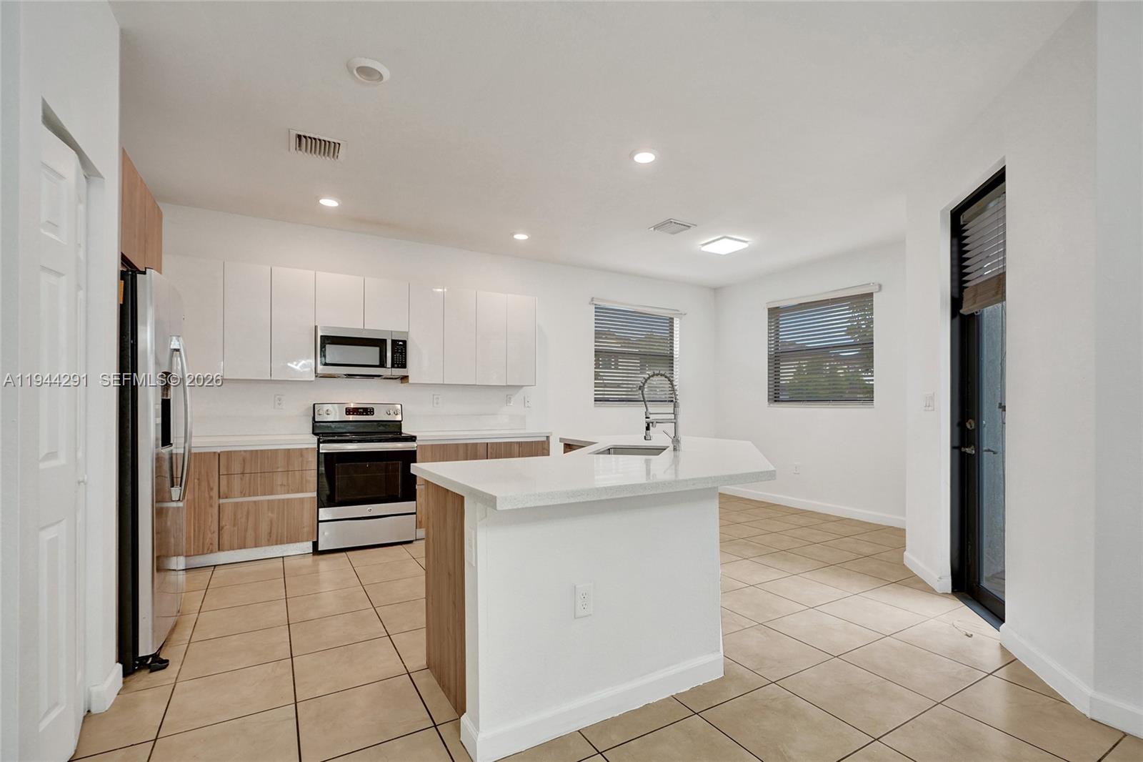 3504 West 94th Street Hialeah, FL 33018 - Photo 14 of 61 a kitchen with stainless steel appliances a stove refrigerator sink and microwave