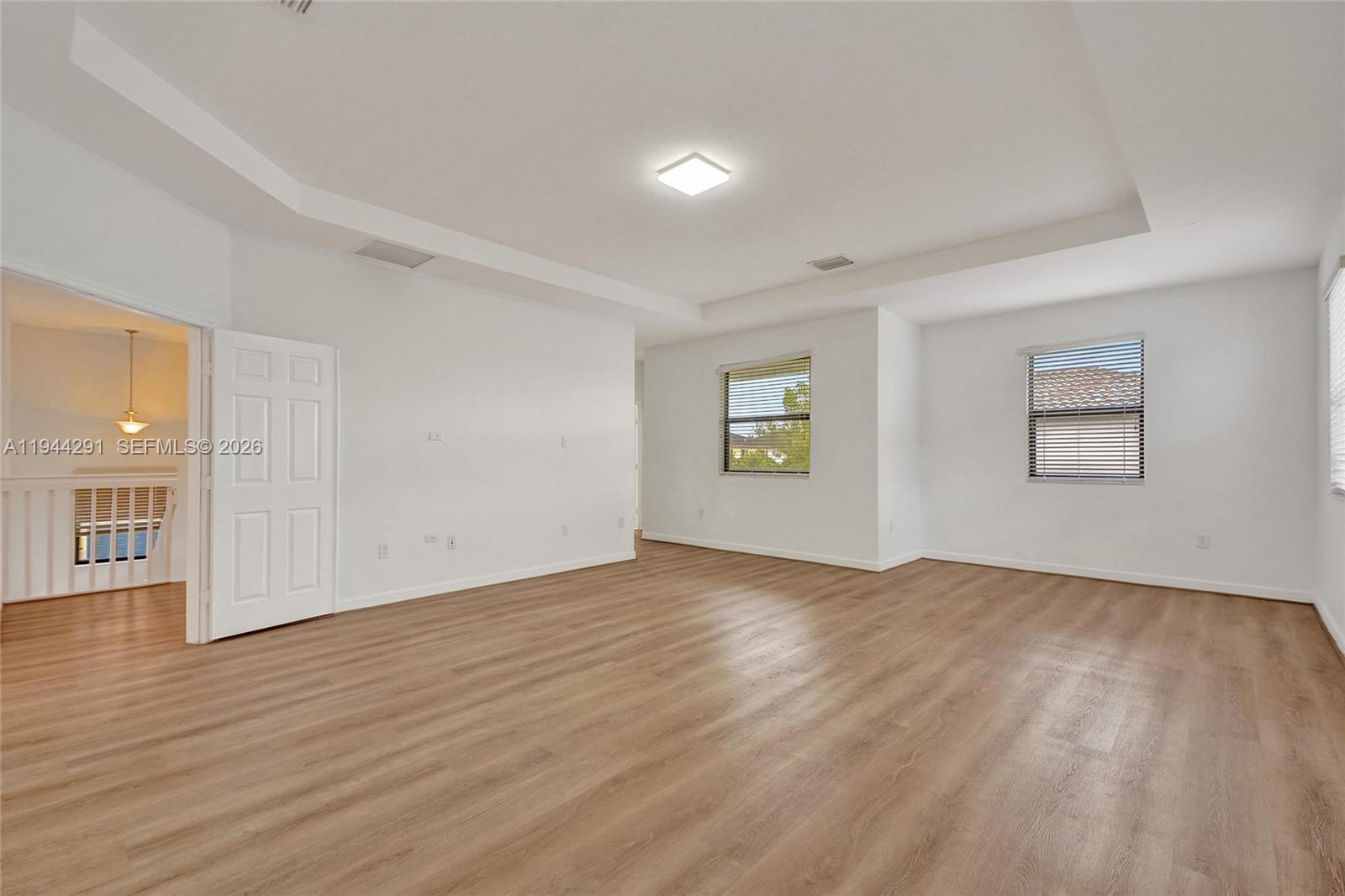 3504 West 94th Street Hialeah, FL 33018 - Photo 31 of 61 an empty room with wooden floor and windows